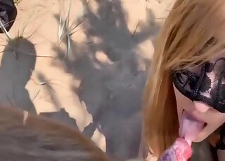 Black mask chick decides to suck on an animal's cock outdoors